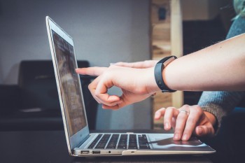 people pointing at laptop downstreet