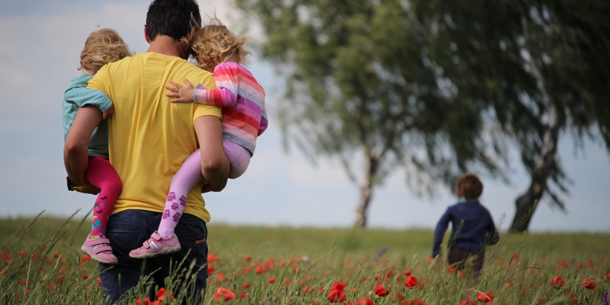 family walking in field of flowers