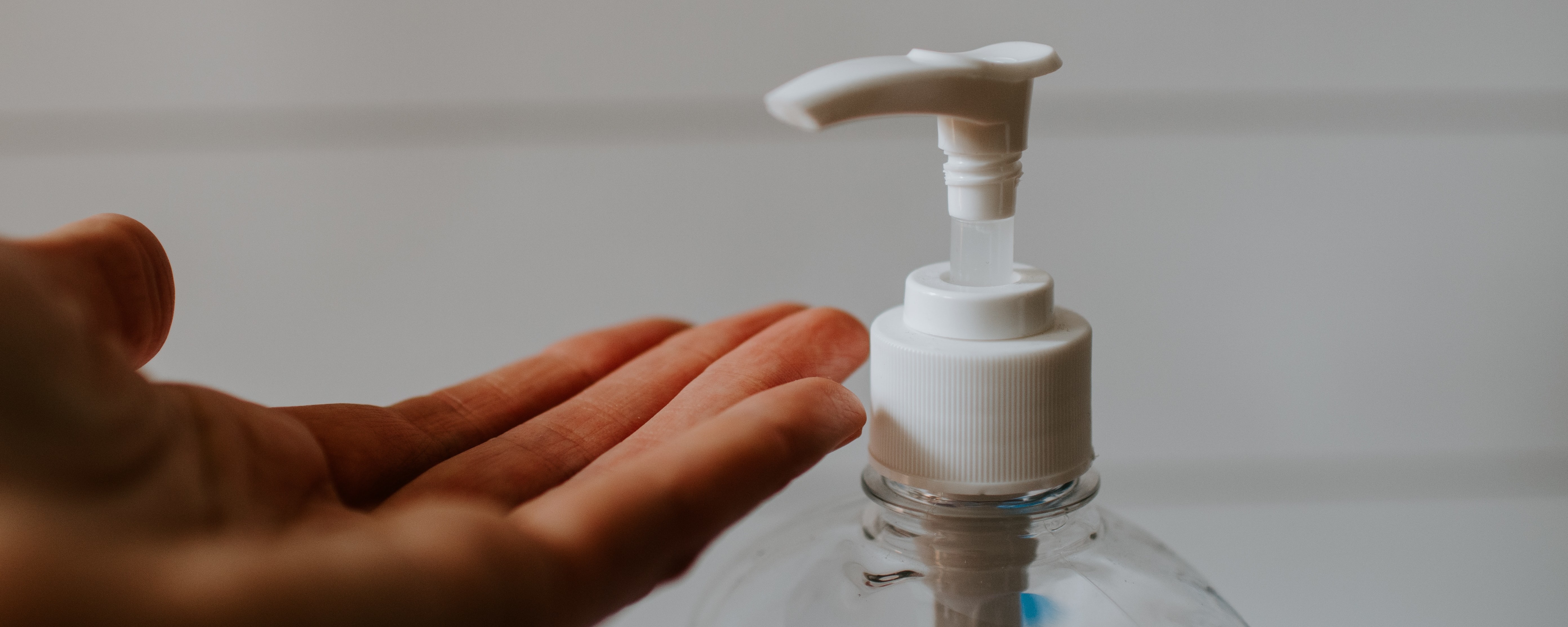 person pumping hand sanitizer