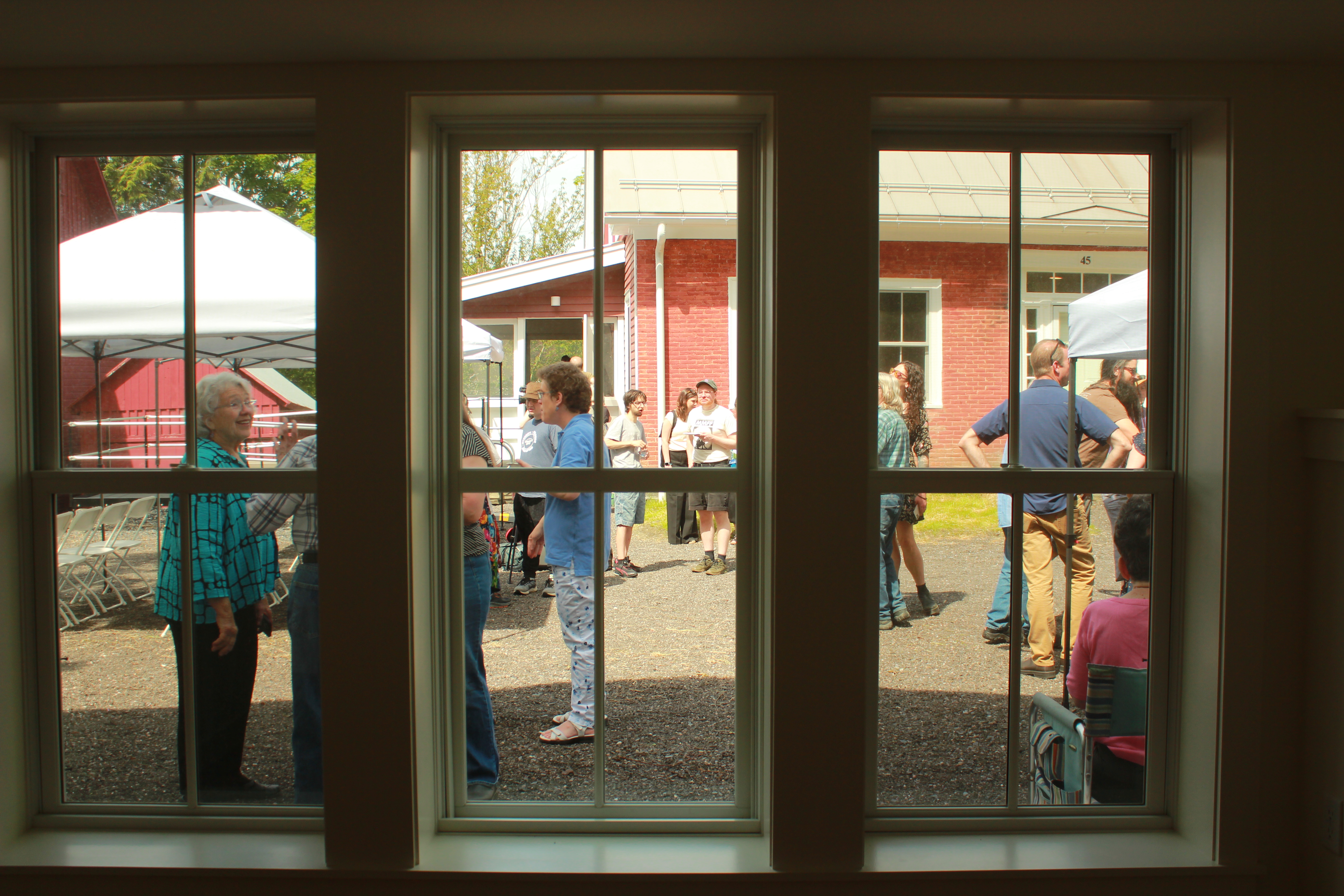 Image of folks standing outside of a window at a Downstreet event