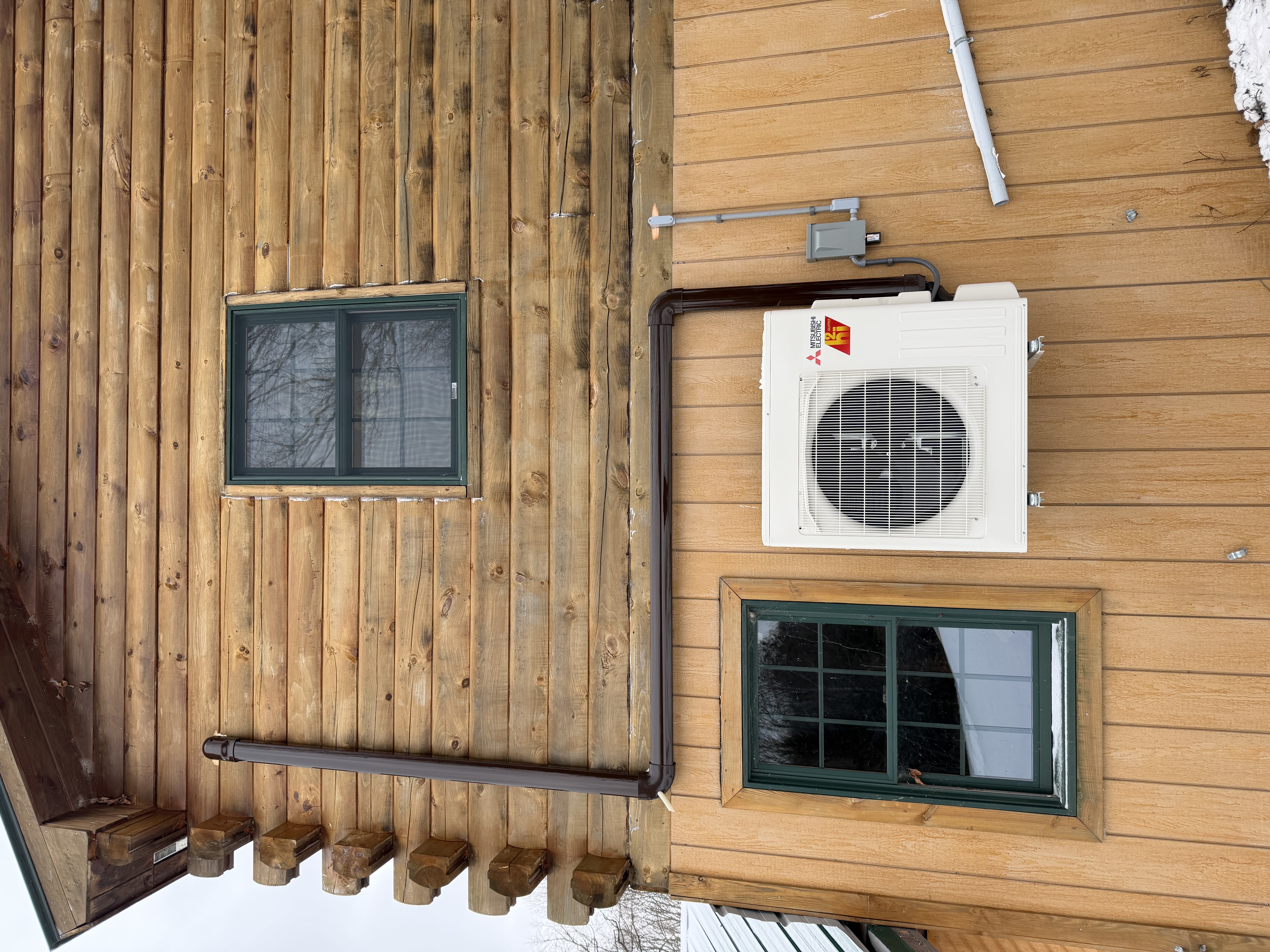 Image of a home exterior with a heat pump, added with help from Green Mountain Home Repair